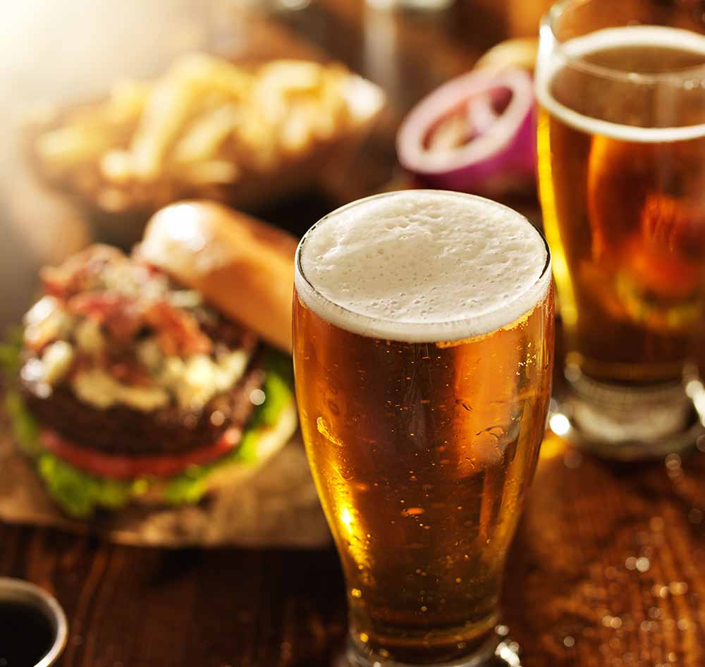 Beer with a burger in the background