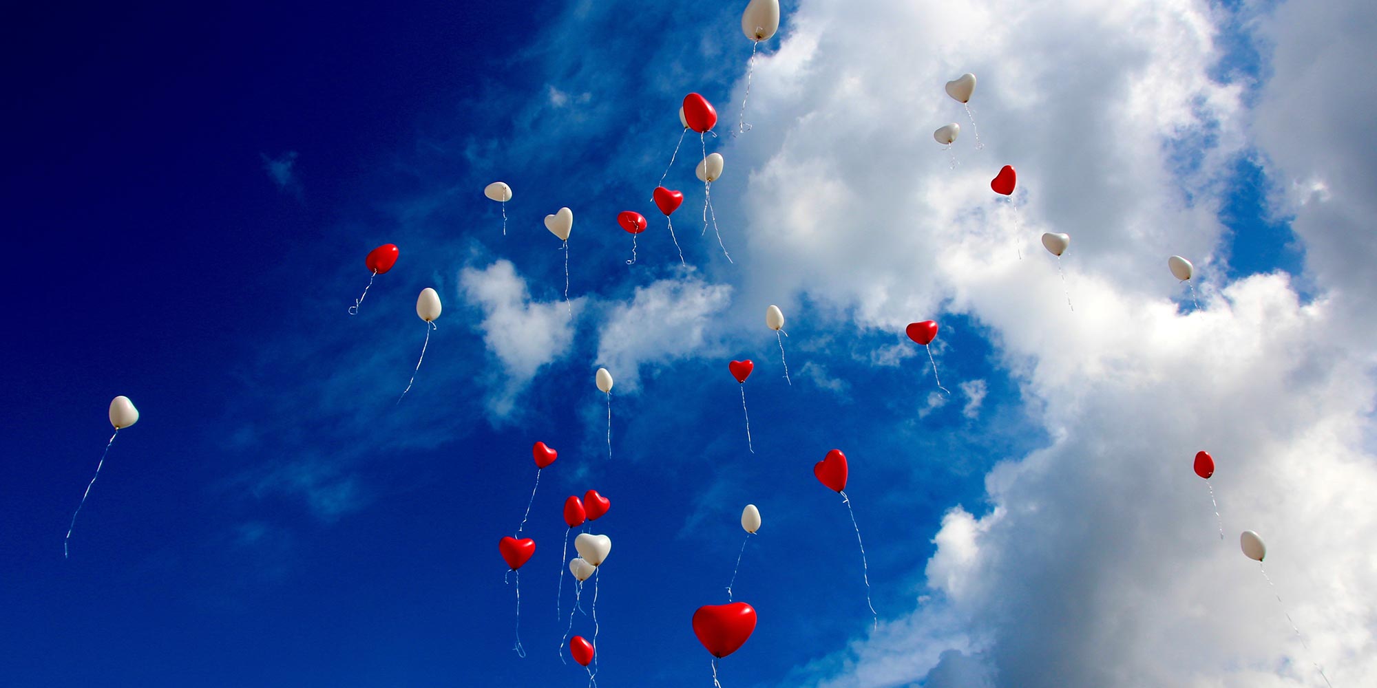 heart shaped balloons floating into the sky